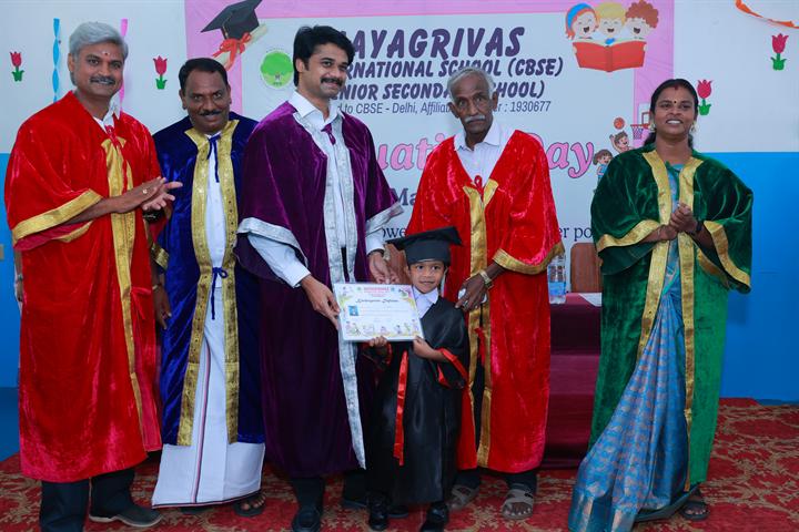 A young graduate in cap and gown receives a certificate on Graduation Day