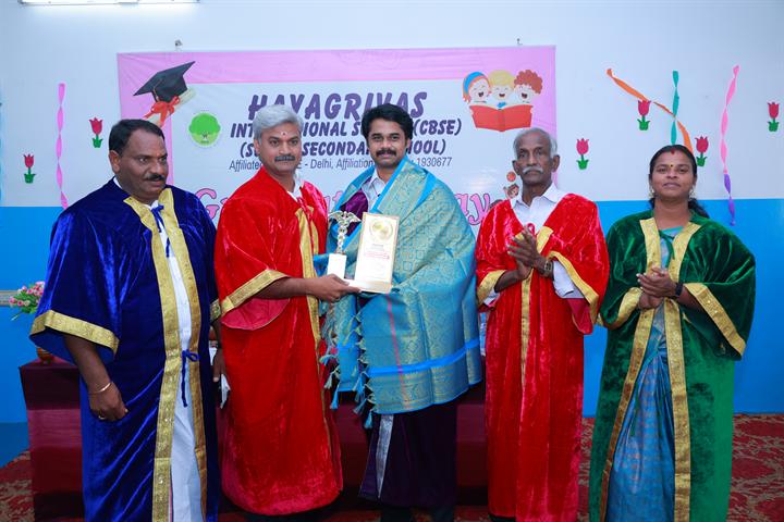 Guests in academic robes on stage at Graduation Day