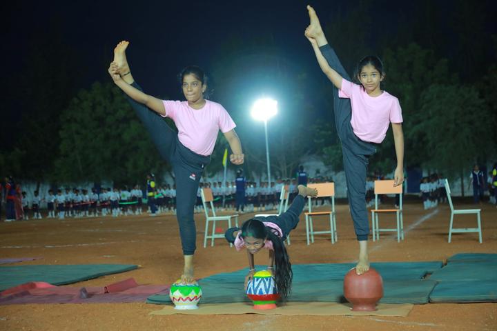 Students hold a yoga balance on clay pots