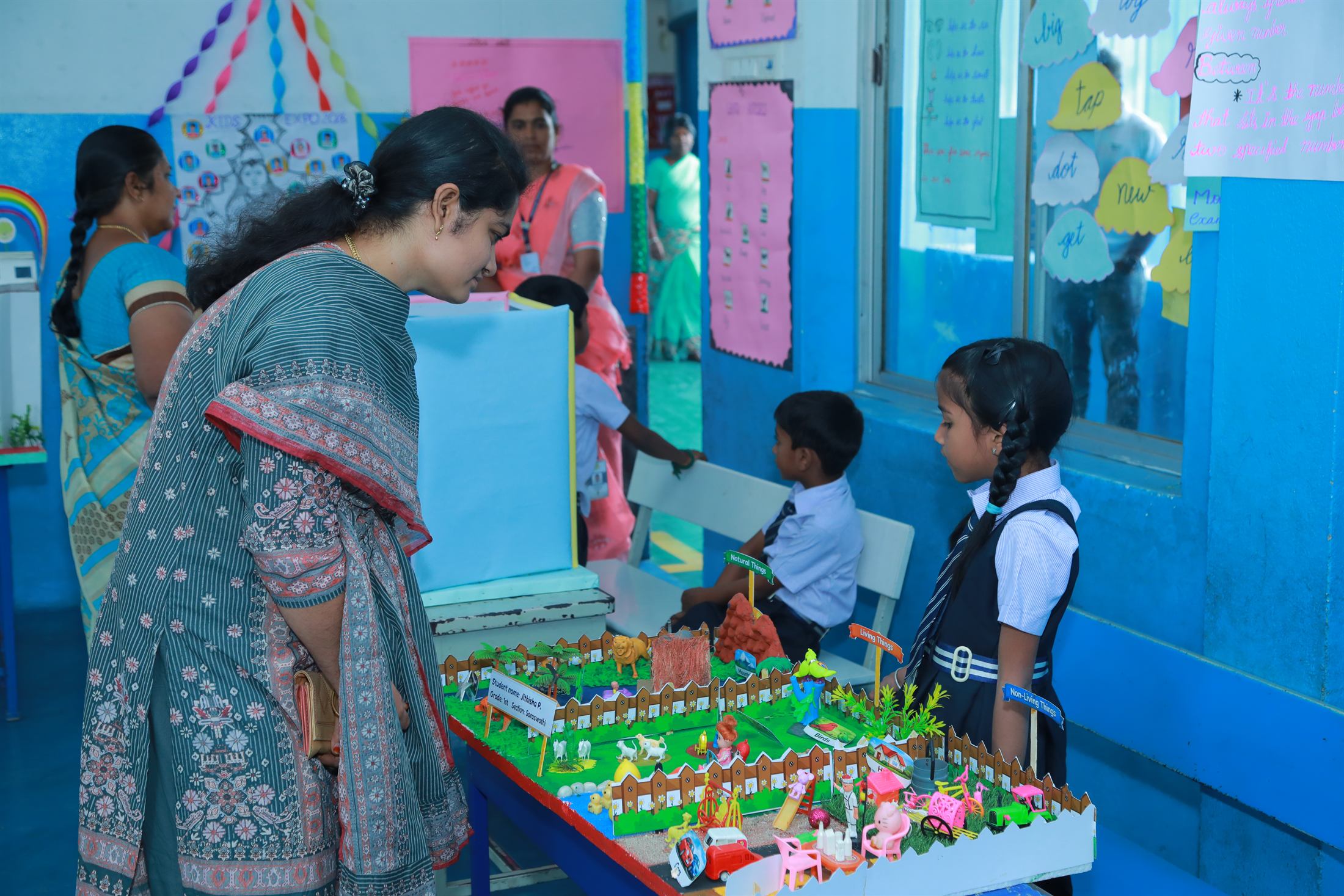 A teacher and students at a science exhibition model